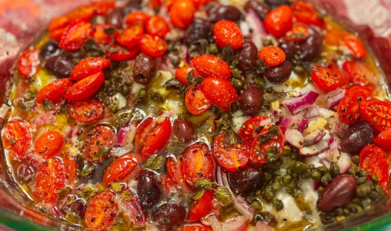 Baked tomatoes, olives, capers and fish in white wine and lemon with oregano