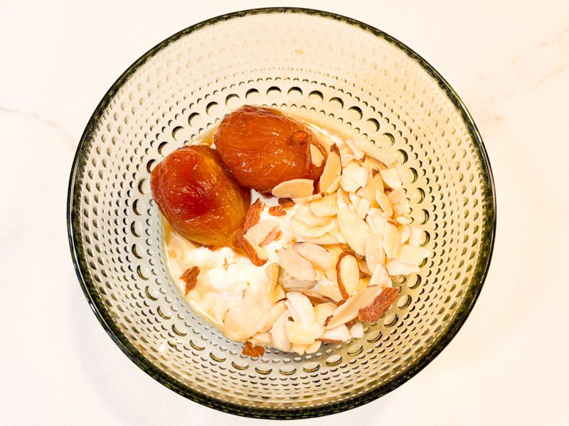 Poached figs with sliced almonds over Greek yogurt
